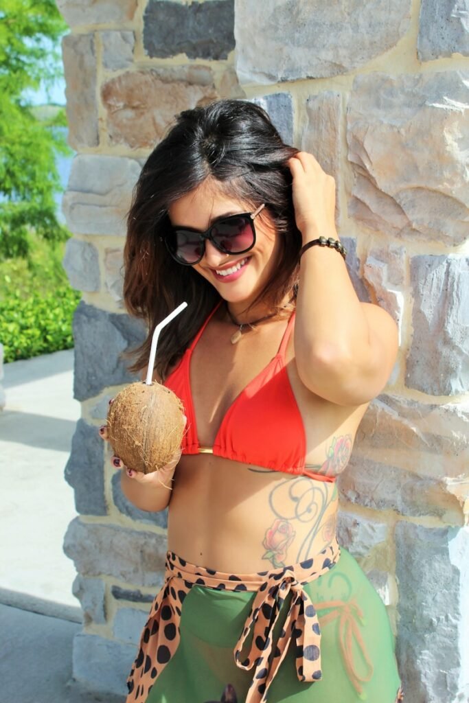 a woman in a bikini holding a coconut during a Sri Lanka tour