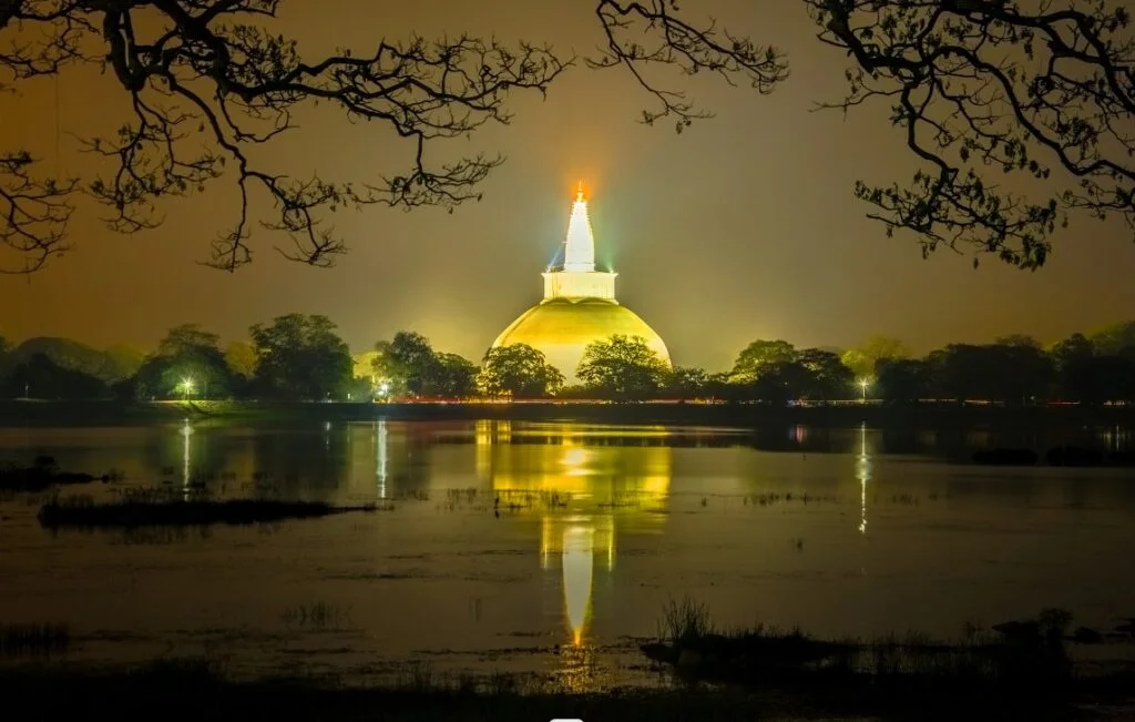 a cultural triangle of sri lanka temple near lake, lighting up night sky and surrounding